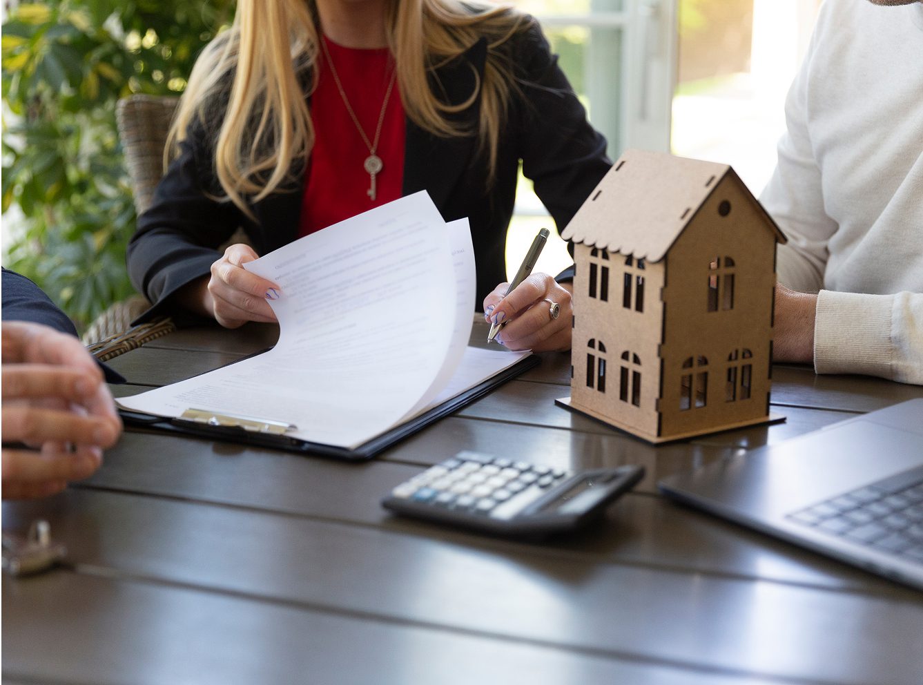 Real estate contract signing with model house.